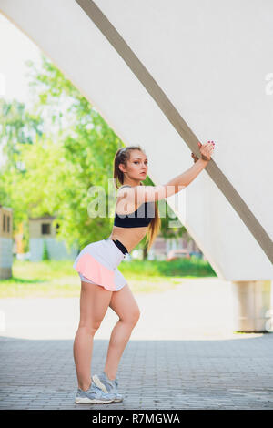 Fitness sporty girl wearing fashion sportswear over street wall