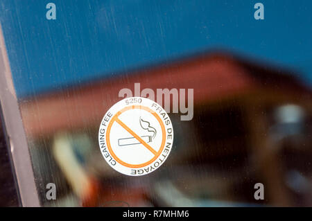 A No Smoking sticker in a hire car window warns of a $250 cleaning fee. Stock Photo