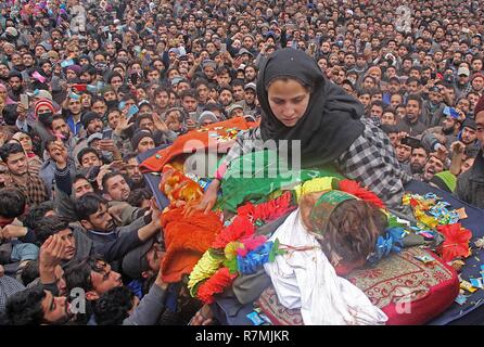 Hajin, Kashmir. 10th December, 2018. Sister of a 14 year old militant Mudasir Rashid sits next to the dead body during the funeral ceremony in Hajin area of north Kashmir some 35 kilometers from Srinagar the summer capital of Indian controlled Kashmir on December 10, 2018. Fourteen year old was among the three militants killed in 18-hour long gun-battle in Mujigund area on the Srinagar outskirts on December 09, 2018. Credit: Faisal Khan/Pacific Press/Alamy Live News