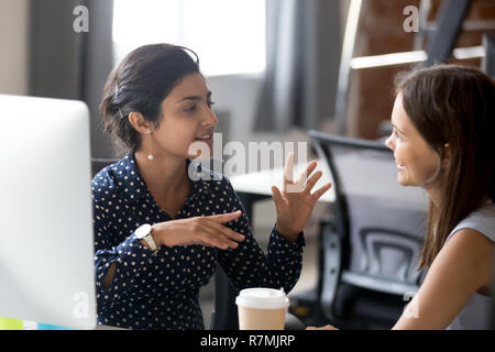 Friendly female colleagues are having pleasant conversation Stock Photo