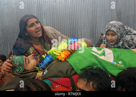 Hajin, Kashmir. 10th December, 2018. (EDITORS NOTE: Image depicts death) Mother and sister of a teenage militant Sakib Bilal sit next to the dead body during the funeral ceremony in Hajin area of north Kashmir some 35 kilometers from Srinagar the summer capital of Indian controlled Kashmir on December 10, 2018. Fourteen year old was among the three militants killed in 18-hour long gun-battle in Mujigund area on the Srinagar outskirts on December 09, 2018. Credit: Faisal Khan/Pacific Press/Alamy Live News