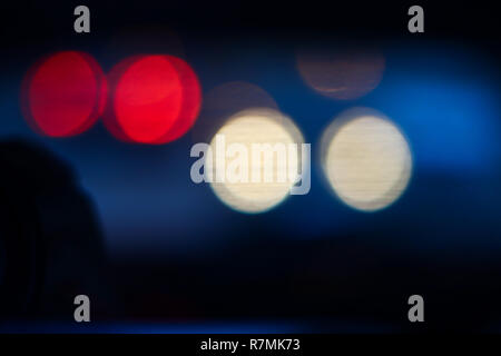 City traffic lights at night, white and red abstract blurry circles on black background Stock Photo