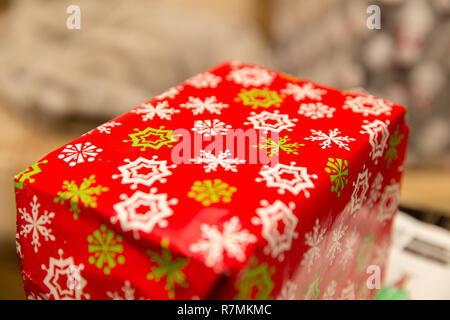 Rectangular box wrapped in red, white, and green wrapping paper. Stock Photo