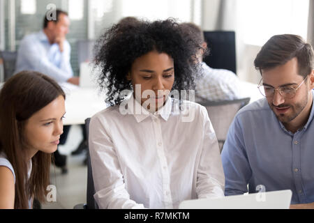 Office workers with African American female leader using laptop Stock Photo