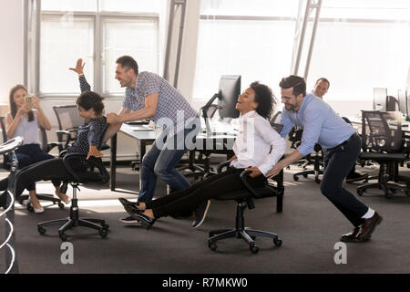 Excited diverse employees having fun together in office Stock Photo