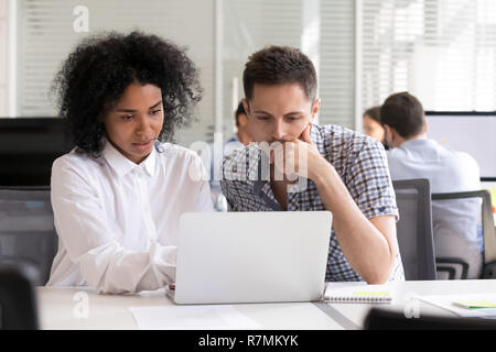 Serious diverse office colleagues discussing online project resu Stock Photo