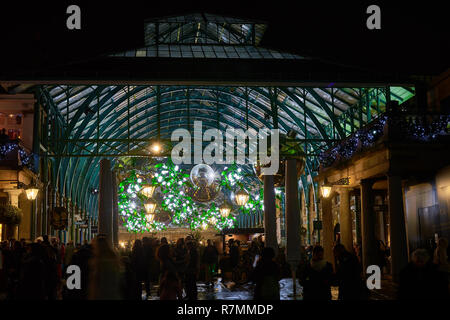 christmas lights hang above shops in the covered market at Covent Garden Market, London, 2018 Stock Photo