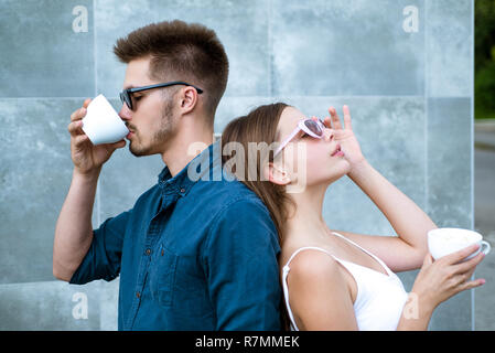 Stop and smell the coffee. Couple of woman and man with coffee cups. Enjoying the best coffee date. Couple in love drink coffee outdoor. Girlfriend and boyfriend have espresso or latter drink Stock Photo