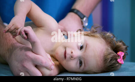 An occupation with baby with cerebral palsy. Physiotherapy. Close up Stock Photo