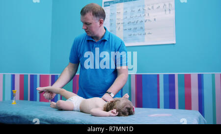 Medical clinic. An occupation with baby with cerebral palsy. Physiotherapy Stock Photo