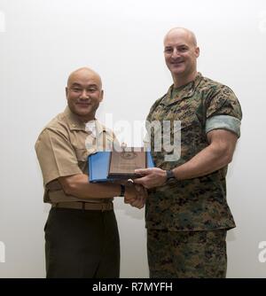 U.S. Marine Corps Col. Daniel L. Shipley, Marine Aircraft Group (MAG) 12 commanding officer, right, presents U.S. Navy Lt. Cmdr. Philip N. Park with the Naval Chaplaincy Excellence award for his outstanding commitment to his duty as the MAG 12 head chaplain at Marine Corps Air Station Iwakuni, Japan, March 21, 2017. The ceremony recognized Park for helping Marines by providing religious, financial and family counseling services. Stock Photo