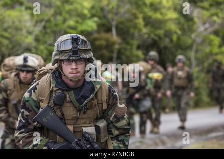 U.S. Marine Corps Cpl. Devin Johnson, Assistant Incident Commander, with Chemical, Biological, Radiological and Nuclear (CBRN) Platoon, G-3, 3d Marine Division, hikes to from Landing Zone Dodo to Combat Town, Okinawa, Japan, March 21, 2017. The CBRN Platoon conducts response drills to enhance the commander’s capabilities by exercising the operability and efficiency of the consequence management set within the 3d Marine Division CBRN response element. Stock Photo