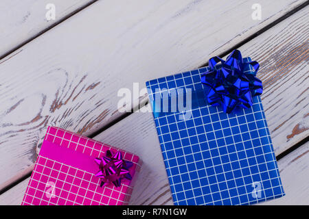 Beautiful gift boxes on wooden background. Two gift boxes wrapped in different colored paper with copy space. Festive holiday background. Stock Photo