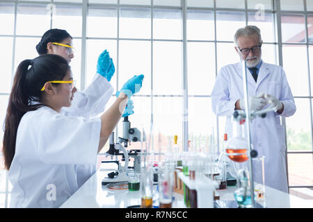 Medical Research and Scientists are working with a microscope and a tablet and Test Tubes, Micropipette and Analysis Results in a laboratory. Stock Photo