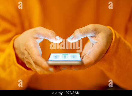 Close up of teenager or adult woman playing online and sending text on smart phone with a colorful background light from the screen in Mobile addictio Stock Photo