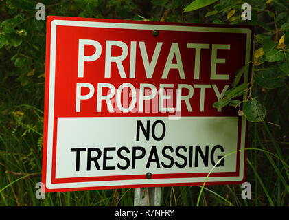 No Trespassing Private Property Sign in Green Bushes. Stock Photo