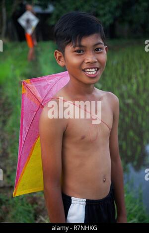 Indonesia, Java, Ijen, Boy with a kite in the back, in the middle of rice fields Stock Photo