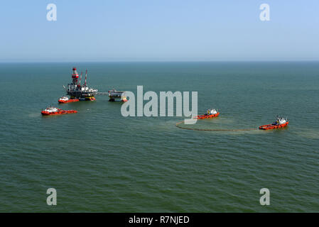 Rescue ships deploy a marine boom during the fire fighting training exercises on the oil rig Lukoil Filanovsky at the Caspian sea, Russia. Stock Photo