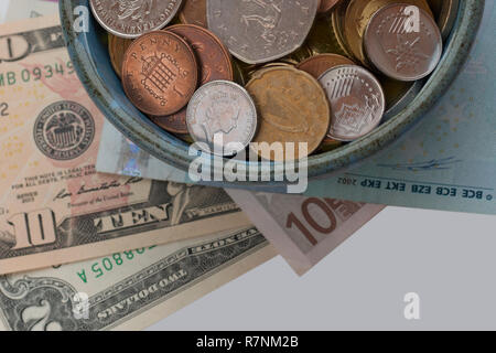 Cup of plenty. Treasure concept. Coins and banknotes from different countries. Symbol of wealth and abundance. Stock Photo