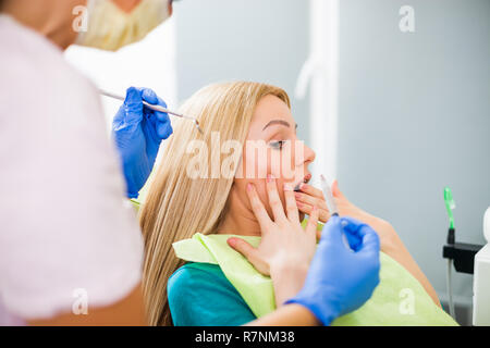 Young woman at dentist. She is afraid. Stock Photo