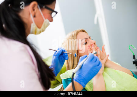 Young woman at dentist. She is afraid. Stock Photo
