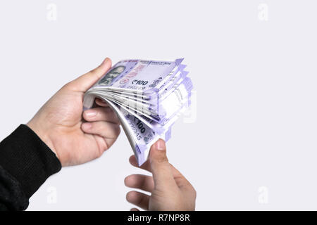 Hand with new Indian currency notes. Isolated on the white background. Stock Photo