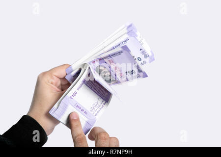 Picture of hand with new Indian currency notes. Isolated on the white background. Stock Photo