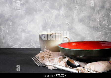 Handmade clay dishes of different colors. on black concrete. dishes, cups. antique cutting board. set for food. Stock Photo