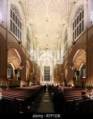 A wide angle view of the main central nave with Gothic pointed arches and stained glass window in the Bath Cathedral, in United Kingdom Stock Photo