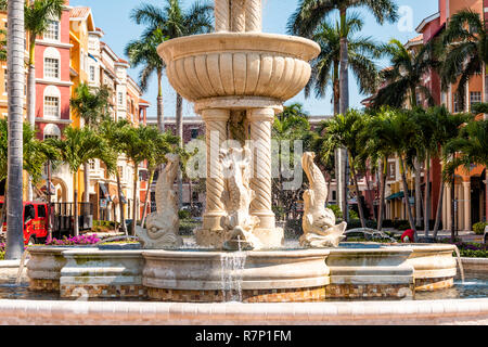Naples, USA - April 30, 2018: Bayfront residential community and shopping center with water fountain, palm trees, blue sky in Florida Stock Photo