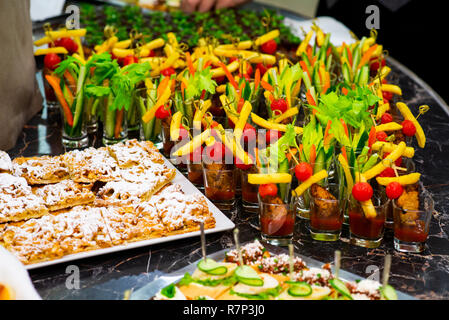 canapes and cold appetizers on the buffet table, meat, vegetables and herbs on a tray Stock Photo