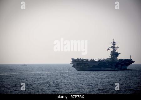 WATERS EAST OF THE KOREAN PENINSULA (March 22, 2017) The Nimitz-class aircraft carrier USS Carl Vinson (CVN 70) and blanksubmarine steam ahead of the Arleigh Burke-class guided-missile destroyer USS Stethem (DDG 63) during a surface maenuvers exercise with several other U.S. and Republic of Korea Navy ships and submarines during Foal Eagle (FE) 17. FE 17 is a series of annual training events designed to increase readiness to defend the ROK, protect the region, and maintain stability in the Korean Peninsula. Stock Photo