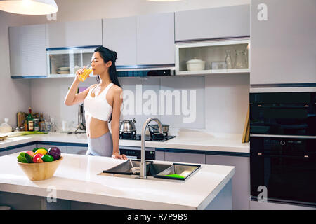 Wearing a sportswear young woman in the kitchen Stock Photo