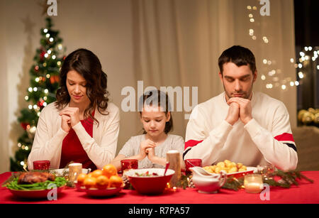 family praying before meal at christmas dinner Stock Photo