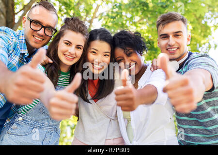 happy friends making thumbs up in park Stock Photo