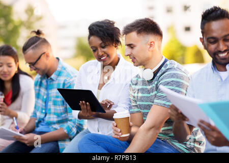 happy students with tablet pc and coffee outdoors Stock Photo
