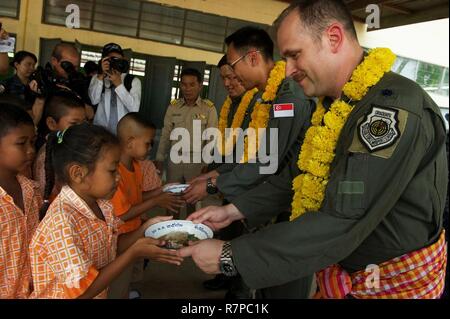 U.S. Air Force Lt. Col. James McFarland, exercise director for Cope Tiger 17 (CT17), along with the Republic of Singapore air force and Royal Thai air force exercise directors participate in lunch service for students of Ban Tanod Poonpol Witthaya School, Nakhon Ratchasima Province, during a combined civic action engagement in Thailand, March 22, 2017. The combined civic action engagement provides an outlet for the countries participating in CT17 to give back to the community surrounding Korat Royal Thai Air Force Base. Over 1,200 U.S., Thai and Singaporean military members will participate in Stock Photo