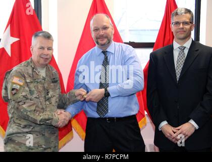 During a March 22, 2017 award ceremony at the U.S. Army Corps of Engineers' North Atlantic Division (NAD) headquarters at Fort Hamilton, Brooklyn, N.Y., Lt. Gen. Todd Semonite, 54th U.S. Army Chief of Engineers (left), recognized Mr. Richard Bros (center) with his commander's coin for Bros' work as the acting chief of the NAD Business Management Division. In that role, Bros has provided vitally important continuity and leadership to NAD headquarters' governance and management projects, including planning and executing regional commanders conferences. On the right is the acting Business Directo Stock Photo