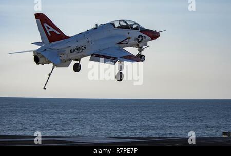 ATLANTIC OCEAN (March 20, 2017) A T-45C Goshawk assigned to Carrier Training Wing (CTW) 1 flies over the flight deck of the aircraft carrier USS Dwight D. Eisenhower (CVN 69) (Ike). Ike is currently conducting aircraft carrier qualifications during the sustainment phase of the Optimized Fleet Response Plan (OFRP). Stock Photo