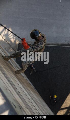 A Marine rappels down a 40-foot tower during event five of the Weapon and Field Training Battalion Gauntlet competition March 24, 2017, on Parris Island, S.C. Event five requires all participants to rappel down a 40-foot tower for the fastest overall time. Teams of five competed in a nine-mile course consisting of nine events varying in military skill and physical difficulty. The day long competition provided an opportunity to build comradeship throughout the Tri-Command through physically demanding events that emphasize sportsmanship and teamwork. (Cpl. Vanessa Austin) Stock Photo