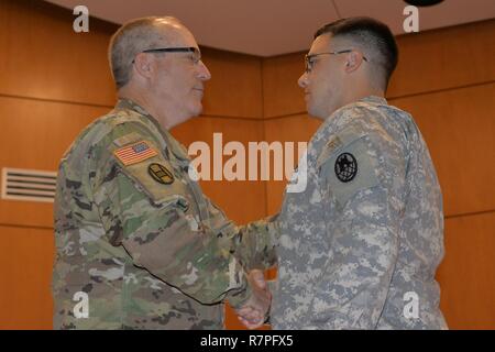 North Carolina National Guard Soldier Spc Robert Shook, right, is honored with the NCNG’s Soldier and Airman Medal (NCSAM) at a ceremony at Guard headquarters in Raleigh, March 24, 2017. “We needed a way to formally recognize those who go beyond,” said Army Maj. Gen. Greg Lusk, the adjutant general of North Carolina, commander of the NCNG, left. Shook is assigned to the 151st Engineer Company. On duty in October 2016, he rushed to the rescue of a nurse who was trapped in floodwaters caused by Hurricane Matthew. He jumped into the rushing water once the nurse lost her grip from a rescue line th Stock Photo