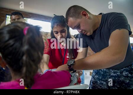 MAYAPO, Colombia (March 25, 2017) - Hospitalman Kyle Jacobs, a native of Dunedin, Fla., attached to Naval Branch Health Clinic Albany, Ga., and a host nation healthcare volunteer perform a blood pressure check on a host nation patient at the Continuing Promise 2017 (CP-17) medical site in Mayapo, Colombia. CP-17 is a U.S. Southern Command-sponsored and U.S. Naval Forces Southern Command/U.S. 4th Fleet-conducted deployment to conduct civil-military operations including humanitarian assistance, training engagements, and medical, dental, and veterinary support in an effort to show U.S. support an Stock Photo