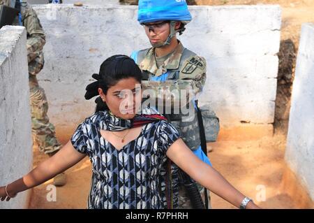 Spc. Maria Hutchinson, a military police officer with the 57th Military Police Company, 728th Military Police Battalion, 8th Military Police Brigade, performs a search on a Nepalese citizen during exercise Shanti Prayas III. Shanti Prayas is a multinational United Nations peacekeeping exercise designed to provide pre-deployment training to U.N. partner countries in preparation for real-world peacekeeping operations. Stock Photo