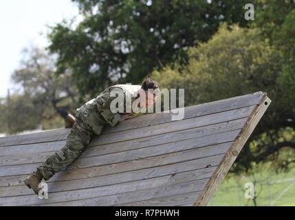 Army Reserve Sgt. 1st Class Farley Thompson, a Tyrone, Ga. native and drill sergeant with Bravo Company, 3rd Battalion, 485th Infantry Regiment, 98th Training Division (Initial EntryTraining), which is located at Fort Benning, Ga., clears an inverted wall obstacle during the 108th Training Command (IET) Drill Sergeant of the Year Competition at Camp Bullis, Texas, March 21, 2017. Stock Photo