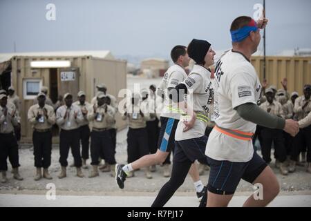 Audience members sing and cheer on runners during a 10-kilometer race March 25, 2017 at Bagram Airfield, Afghanistan. The race was one of several events held during Freedom Fest. Stock Photo