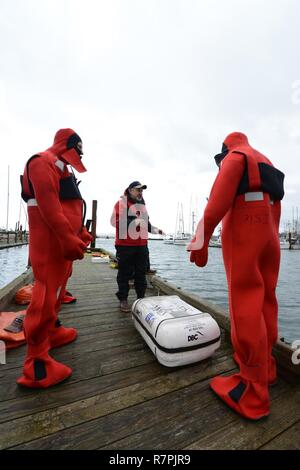Dan Cary, a fishing vessel safety examiner from the Coast Guard's Marine Safety Unit Portland, explains to students how to properly deploy a life raft during an 18-hour drill conductor's course in Newport, Oregon, Mar. 24, 2017. Local commercial fishermen learned how to conduct various emergency drills for the crews aboard their own vessels. U.S. Coast Guard Stock Photo
