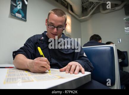 PACIFIC OCEAN (March 25, 2017) Machinist's Mate 3rd class Timothy Cox, from Lancaster, Calif., participates in bingo night hosted by Morale, Welfare and Recreation (MWR) aboard the Ticonderoga-class guided-missile cruiser USS Princeton (CG 59) while underway for composite training unit exercise (COMPTUEX) with the Nimitz Carrier Strike Group in preparation for an upcoming deployment. COMPTUEX tests the mission readiness of the strike group's assets through simulated real-world scenarios and their ability to perform as an integrated unit. Stock Photo