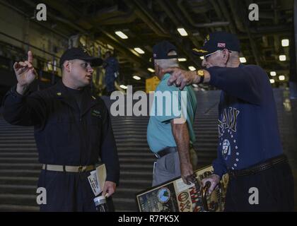 MAYPORT, Fla. (March 24, 2017) – Retired Capt. John Meserve (left) and retired Cmdr. Henry Dronzeck (right) are led on a tour of the amphibious assault ship USS Iwo Jima (LHD 7) by Chief Mass Communication Specialist Michael Lantron. Meserve served as the executive officer of USS Iwo Jima (LPH-2) from 1984-1987 while Dronzeck served as the ship’s secretary and ship handler for Iwo Jima from 1963-1966. Stock Photo