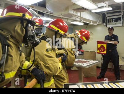 INDIAN OCEAN (March 28, 2017) Boatswain’s Mate 1st Class Carlos Villa, right, from Miami, instructs Sailors how to combat a fire during a damage control drill aboard the amphibious assault ship USS Makin Island (LHD 8).  Makin Island, the flagship for the Makin Island Amphibious Ready Group, with the embarked 11th Marine Expeditionary Unit, is operating in the Indo-Asia-Pacific region to enhance amphibious capability with regional partners and to serve as a ready-response force for any type of contingency.