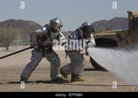U.S. Marines with Marine Wing Support Squadron 271 (MWSS-271) demonstrate the bunker gear drill with pump and roll during a capability brief of their squadron for Marine Aviation Weapons and Tactics Squadron One (MAWTS-1) air ground support students at Site 50, Ariz., March 27, 2017. This brief was a part of Weapons and Tactics (WTI) course 2-17, a seven week training event, hosted by MAWTS-1 cadre, which emphasizes operational integration of the six functions of Marine Corps aviation in support of a Marine Air Ground Task Force. MAWTS-1 provides standardized advanced tactical training and cer Stock Photo